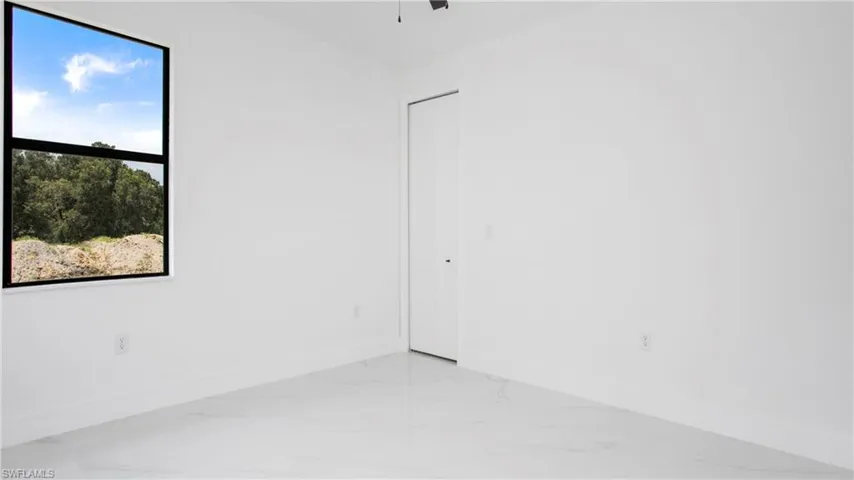 Unfurnished room featuring marble tiled flooring and a ceiling fan