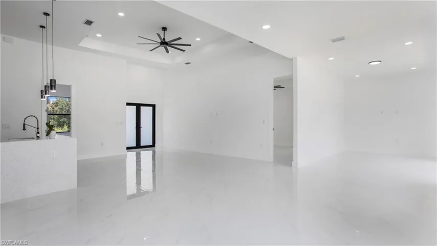 Unfurnished room featuring recessed lighting, light marble finish floors, a raised ceiling, and ceiling fan
