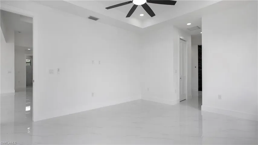 Empty room featuring a ceiling fan, recessed lighting, and light marble finish floors