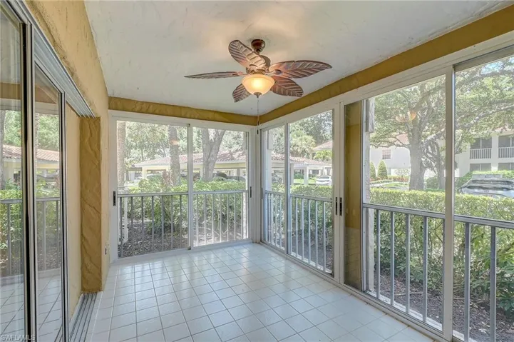 Unfurnished sunroom with a wealth of natural light and ceiling fan