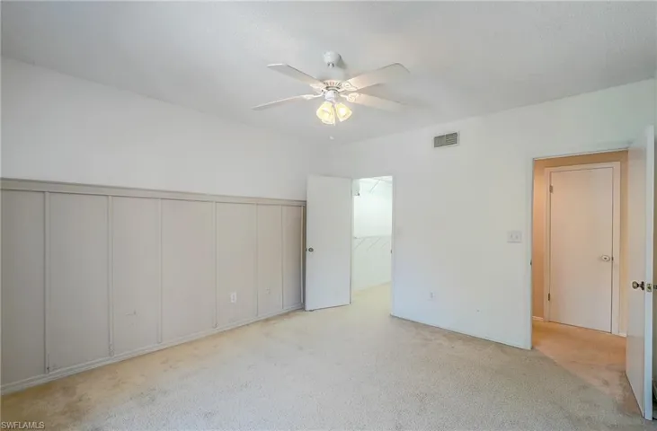 Spare room featuring ceiling fan and light carpet