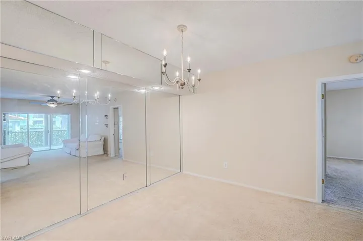 Unfurnished bedroom featuring carpet flooring, a chandelier, and a textured ceiling