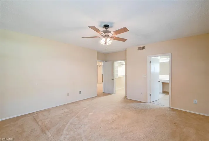 Carpeted spare room featuring ceiling fan