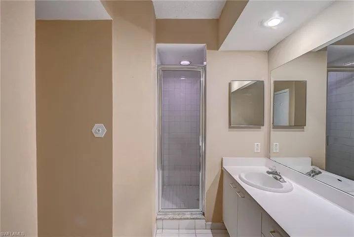 Bathroom featuring tile flooring, a shower with shower door, and vanity