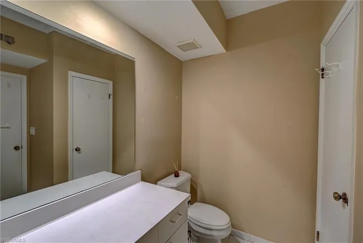 Bathroom featuring tile floors, vanity, and toilet
