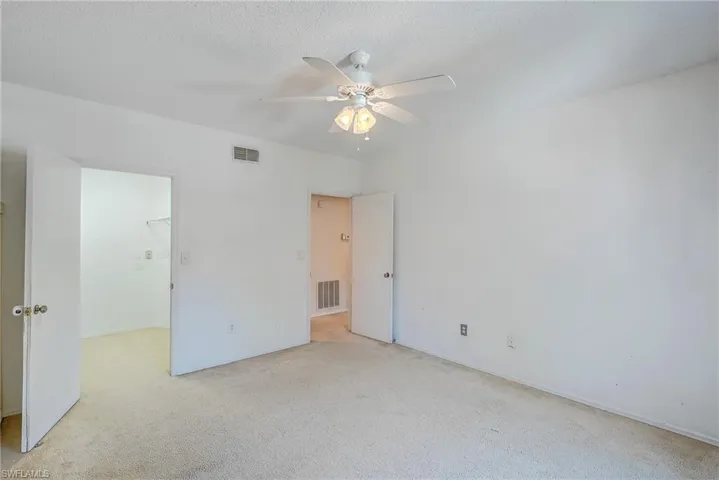 Unfurnished room with ceiling fan and light colored carpet