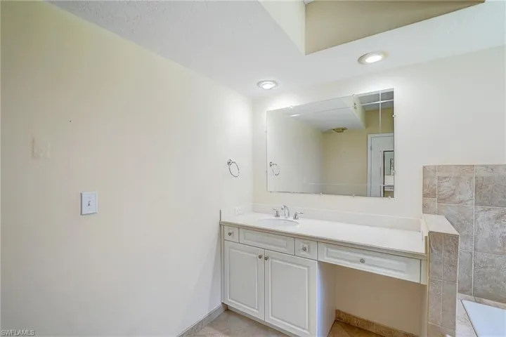Bathroom with tile flooring and vanity with extensive cabinet space