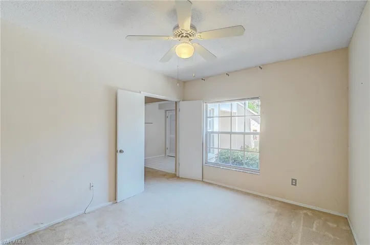 Carpeted spare room featuring ceiling fan and a textured ceiling