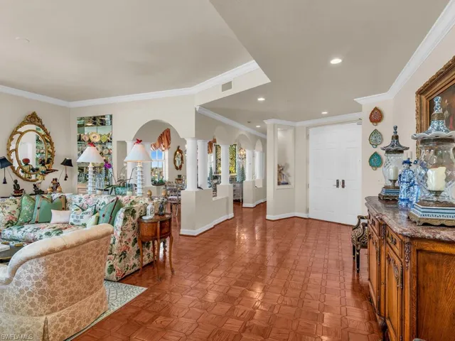 Foyer featuring parquet floors, ornamental molding, and decorative columns