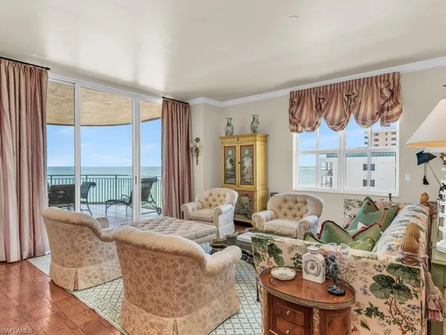 Living room featuring a water view, parquet flooring, and crown molding