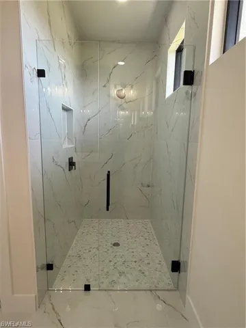 Bathroom featuring a marble finish shower and marble finish flooring