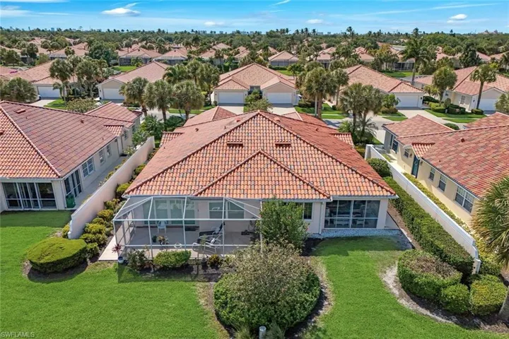 The property features a terracotta tile roof, a screened-in patio, and a well-maintained lawn with manicured hedges