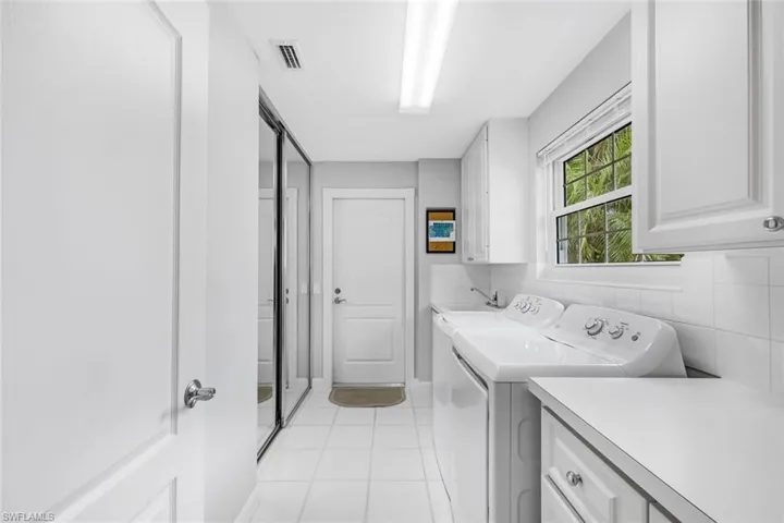 Laundry with sink and storage. Entrance to the 2 car garage.