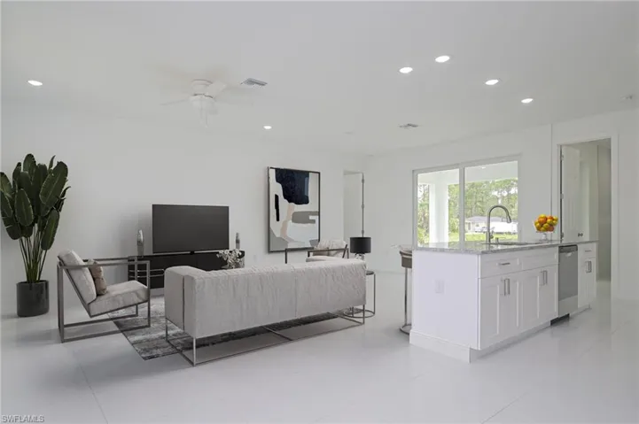 Tiled living room featuring ceiling fan and sink