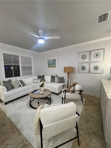 Living room with crown molding and a ceiling fan