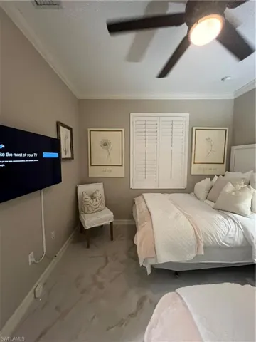 Carpeted bedroom featuring ornamental molding and ceiling fan