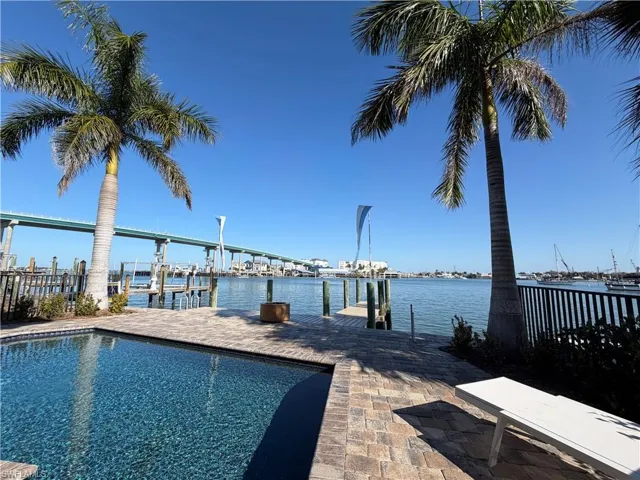Dock area with an outdoor pool, boat lift, and a water view