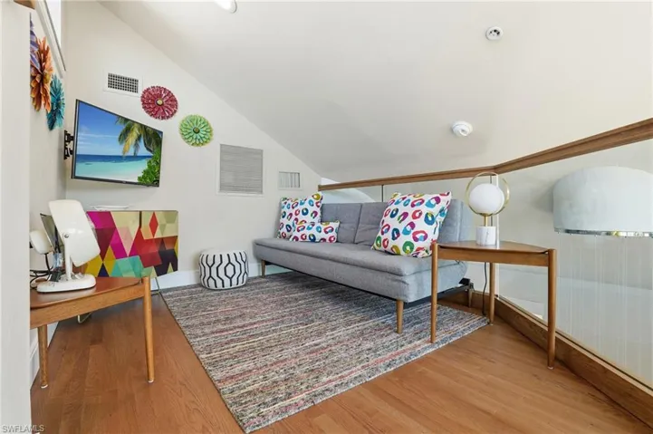 Living room with lofted ceiling and light wood-style floors - Virtually Edited Image