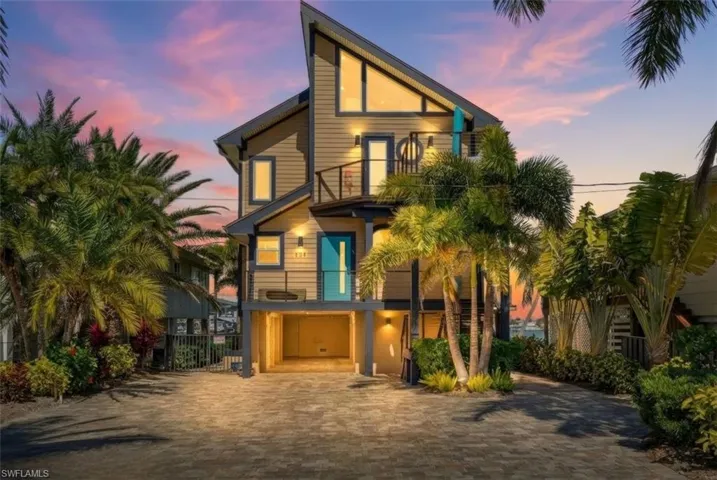 View of front facade featuring a balcony and decorative driveway - Virtually Edited Image