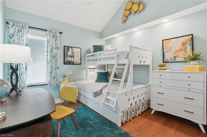Bedroom featuring wood finished floors and vaulted ceiling - Virtually Edited Image