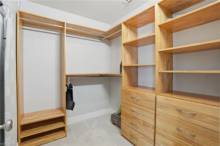 Walk in closet featuring light colored carpet - Virtually Edited Image