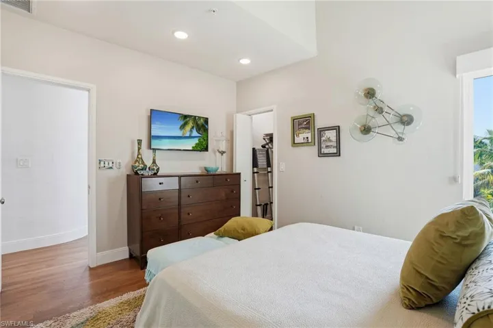 Bedroom with wood finished floors and recessed lighting - Virtually Edited Image