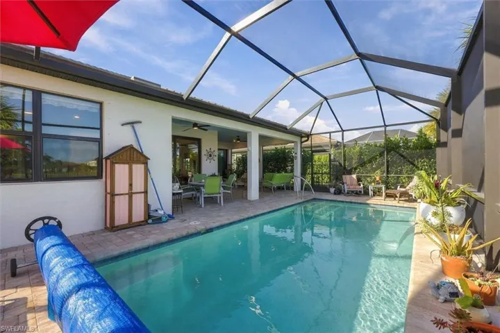 Screened-in patio featuring a swimming pool, paver deck, and covered lanai