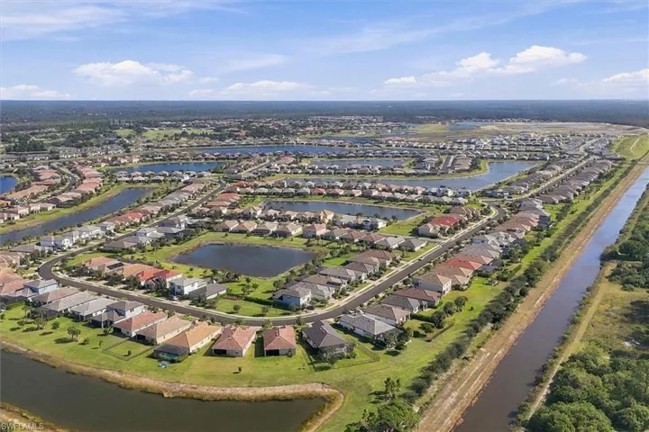 Aerial perspective of a planned community featuring multiple centralized water retention ponds and extensive canal systems