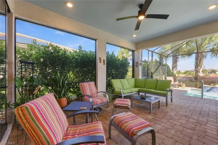 Screened-in lanai featuring paver flooring, recessed lighting, a ceiling fan, and an integrated swimming pool
