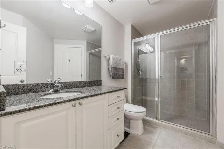 Full bath with vanity, a stall shower, and light tile patterned flooring