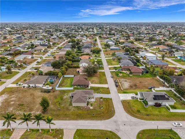 Aerial view of property and surrounding area featuring nearby suburban area