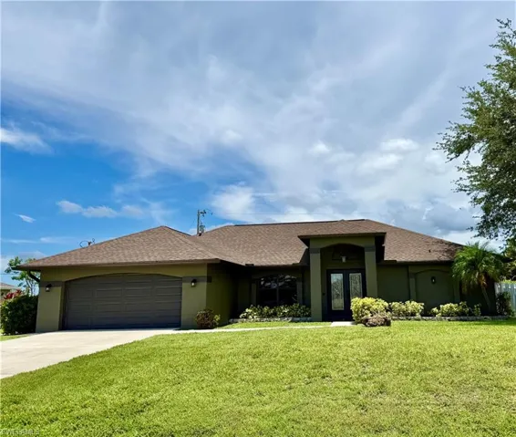 View of front facade with stucco siding, a front lawn, and concrete driveway