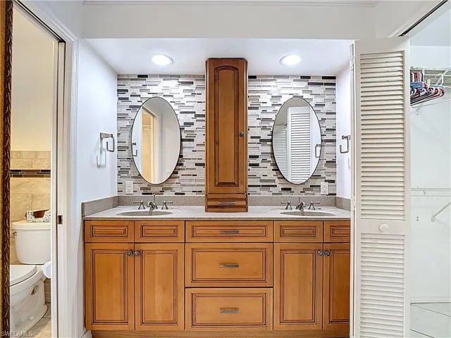 Bathroom with double vanity, tile walls, and light tile patterned floors