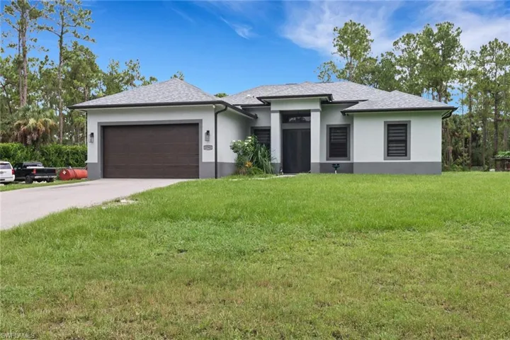 View of front of house featuring a garage and a front yard