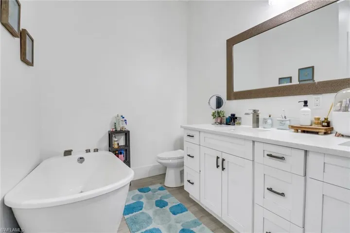 Bathroom with vanity, a washtub, and toilet