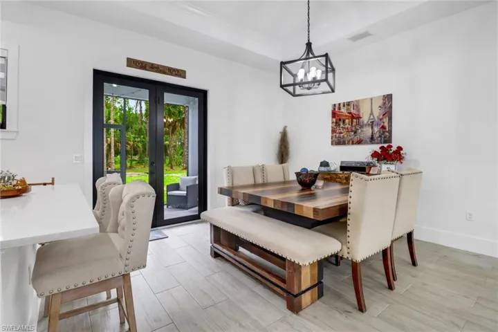 Dining space featuring a chandelier, french doors, and a tray ceiling