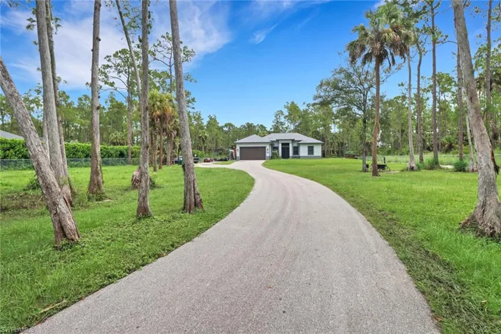 Single story home with a garage and a front lawn