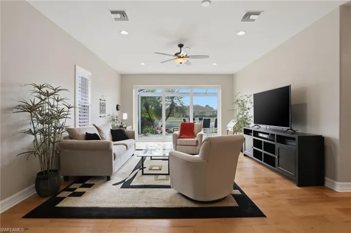 Living area featuring light wood-style flooring, ceiling fan, and recessed lighting