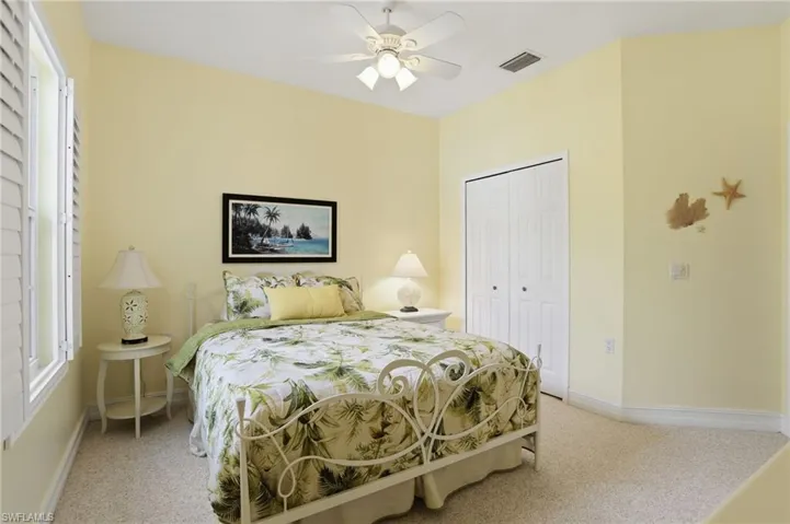 Bedroom with light carpet, a closet, and ceiling fan