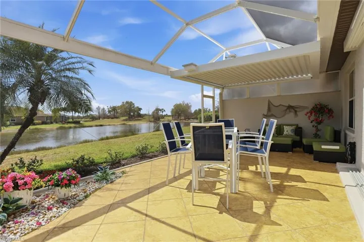 View of patio / terrace with a sunroom, outdoor dining area, and a water view