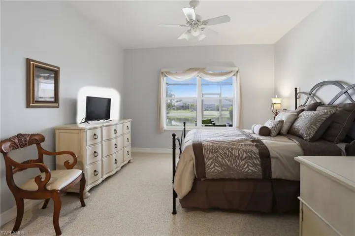 Bedroom with light carpet and a ceiling fan