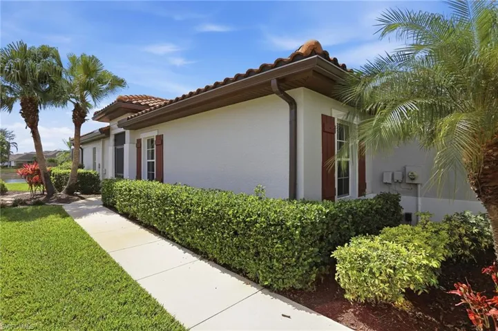 View of home's exterior with stucco siding, a lawn, and a tile roof