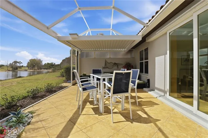 View of patio featuring outdoor dining area, a water view, a sunroom, and a lanai