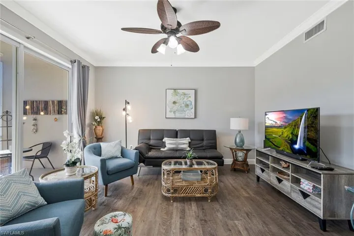 Living area featuring ornamental molding, wood finished floors, and ceiling fan