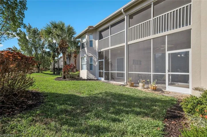 View of grassy yard with a sunroom
