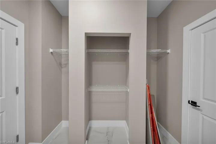 Walk in closet with light marble finish flooring
