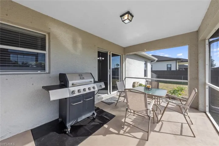 View of patio with outdoor dining area, area for grilling, and fence