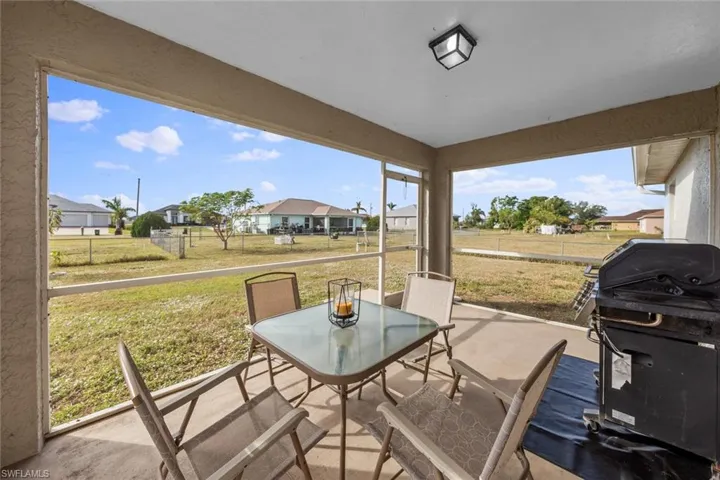 View of patio featuring area for grilling, outdoor dining space, and a residential view
