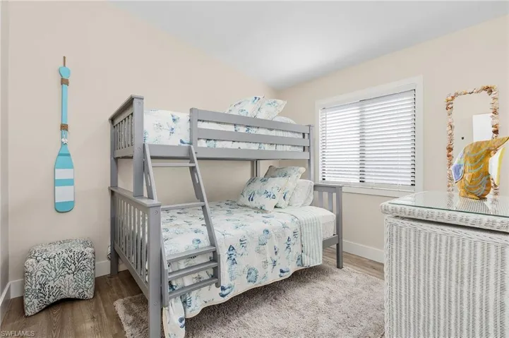 Bedroom with wood finished floors and baseboards