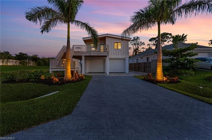 Coastal inspired home featuring a lawn, driveway, an attached garage, and board and batten siding